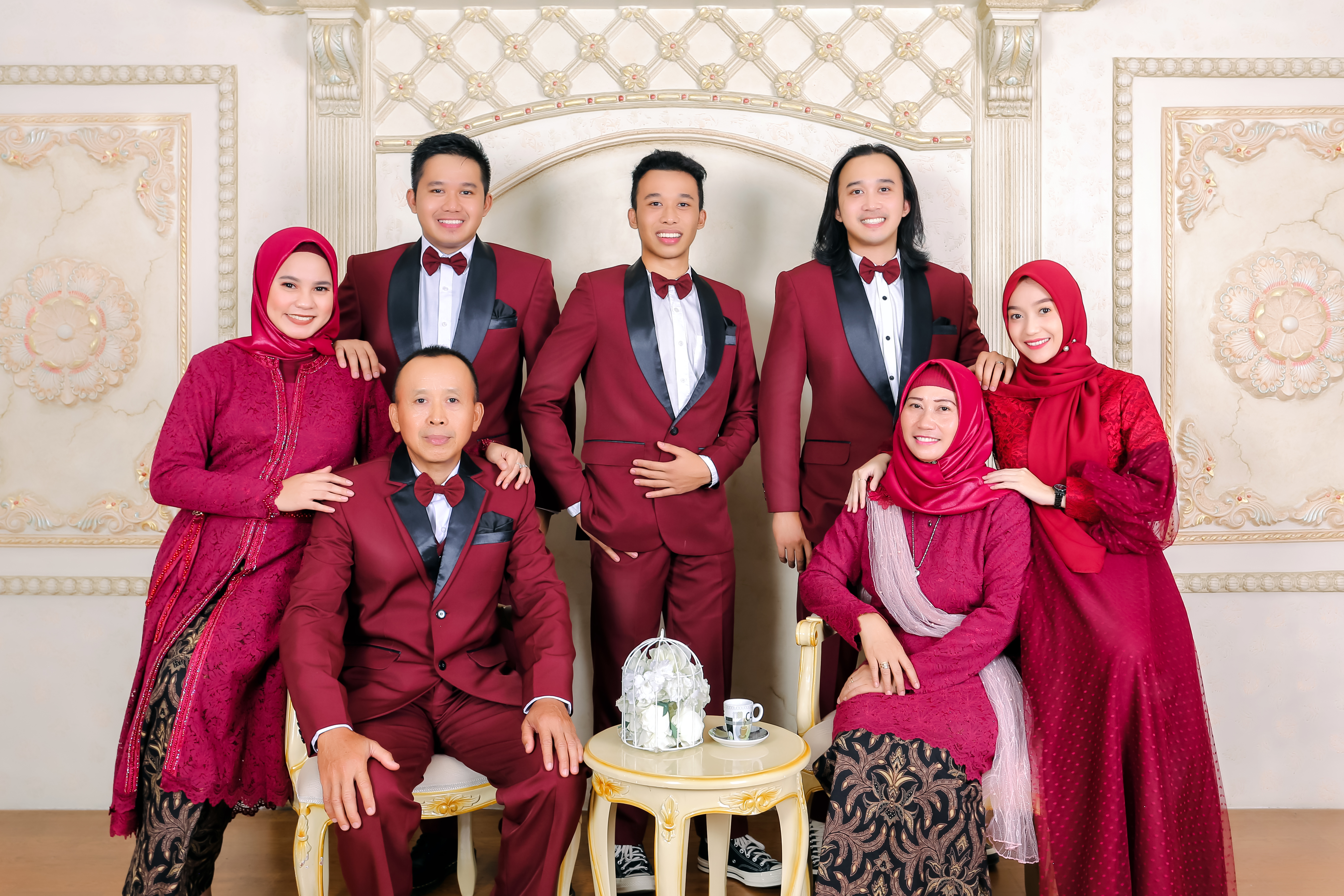 Happy family of four sitting together on a picnic blanket in golden hour lighting