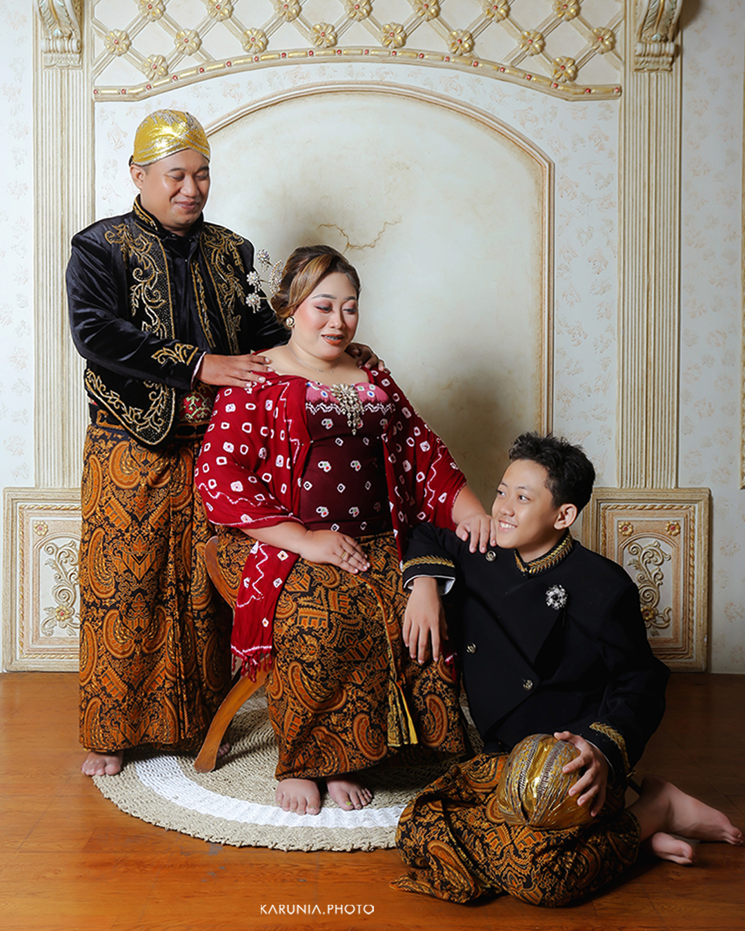 Three siblings sitting on wooden steps in coordinating outfits with genuine smiles and relaxed poses