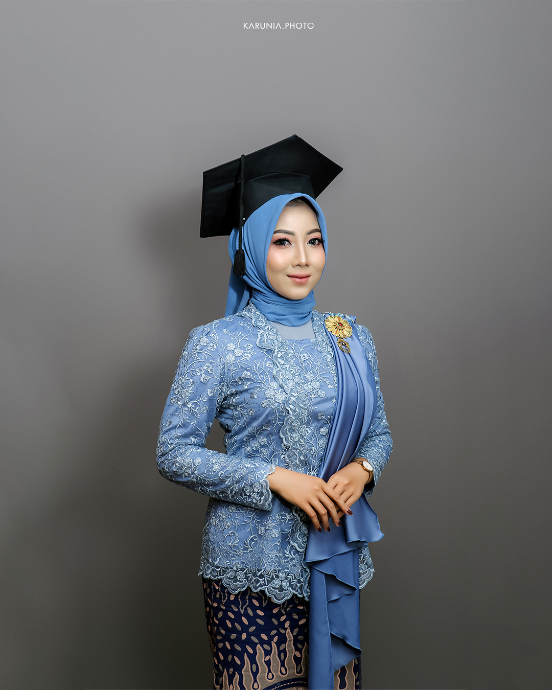 Group of friends in caps and gowns cheering together with arms around each other