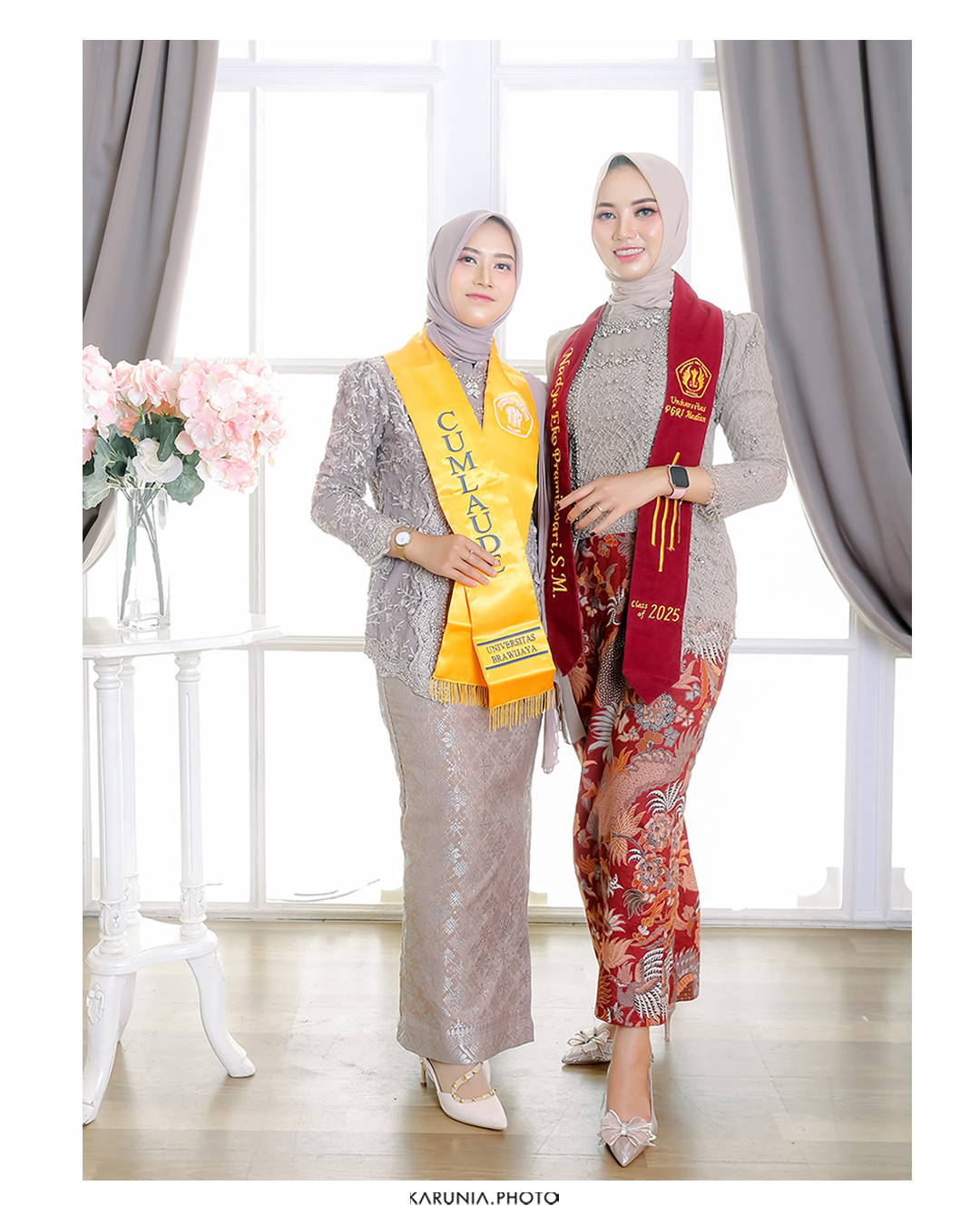 Graduate being hugged by proud parents on campus lawn with university buildings in background